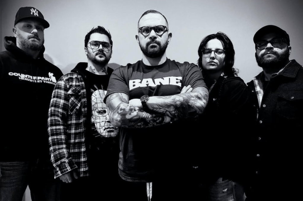 A group of five individuals stands confidently in a black and white portrait, showcasing a mix of styles and expressions.